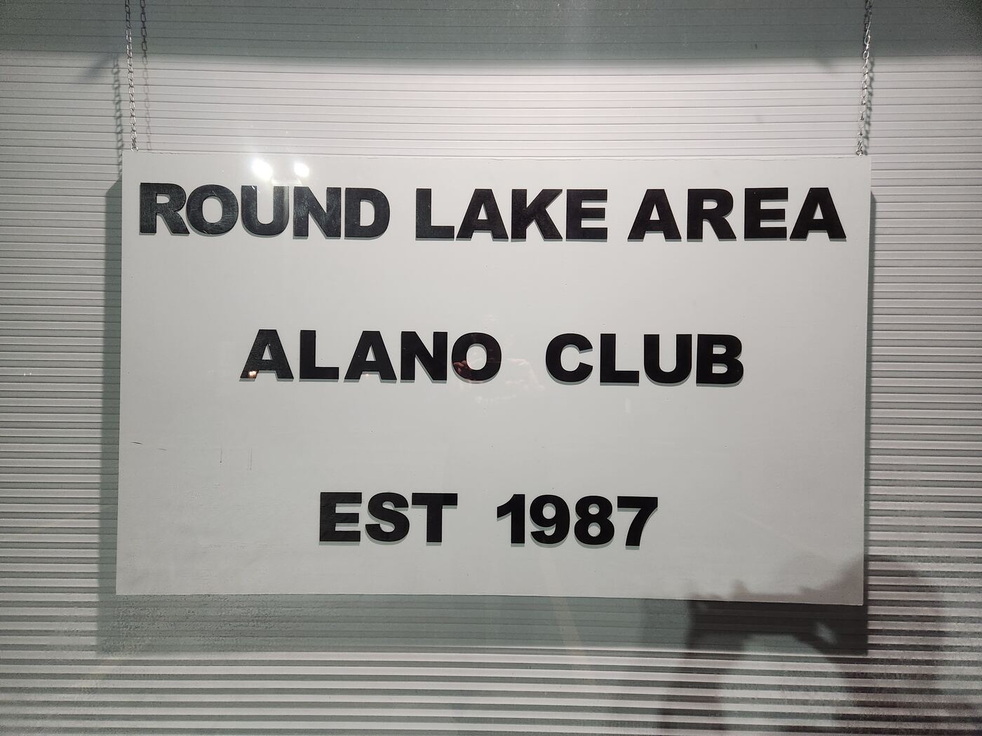 The club’s window sign reading Round Lake Area Alano Club, Est. 1987
